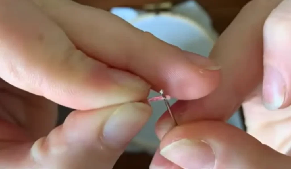 Guide the floss through the needle's eye, forming a loop for threading started.