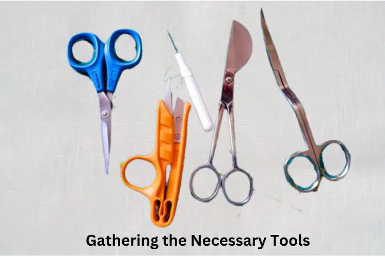 Assorted tools laid out on a table, including small scissors, tweezers, thread and needle, fabric marker, and an iron.